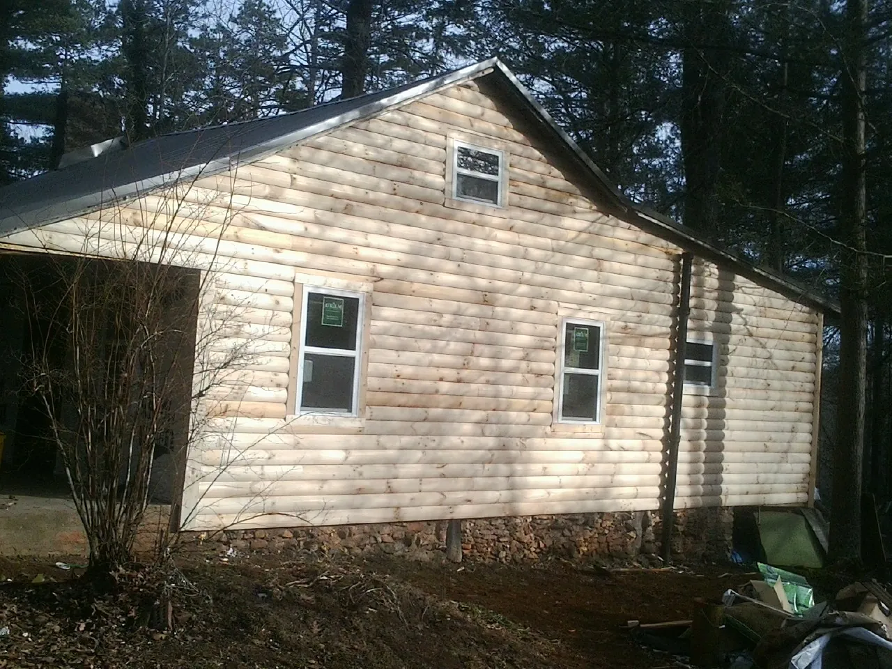 New log siding and dark metal roofing on a gable end in Grampian