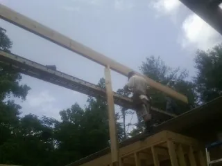 Carpenter setting a ridge beam over a new addition frame — Ice Dam Removal by Roofing Brothers in Grampian