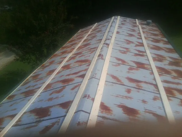 Rusted metal roof panels with new wood purlins before replacement — Storm Damage Roof Repair in Grampian by Roofing Brothers