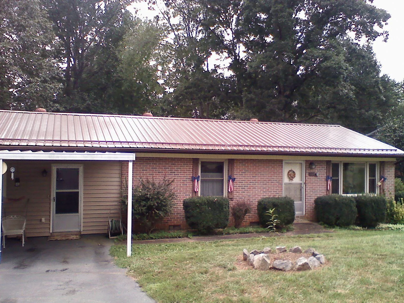 Bronze metal roof and carport on a brick ranch home — Roof Repair work by our crew in Grampian