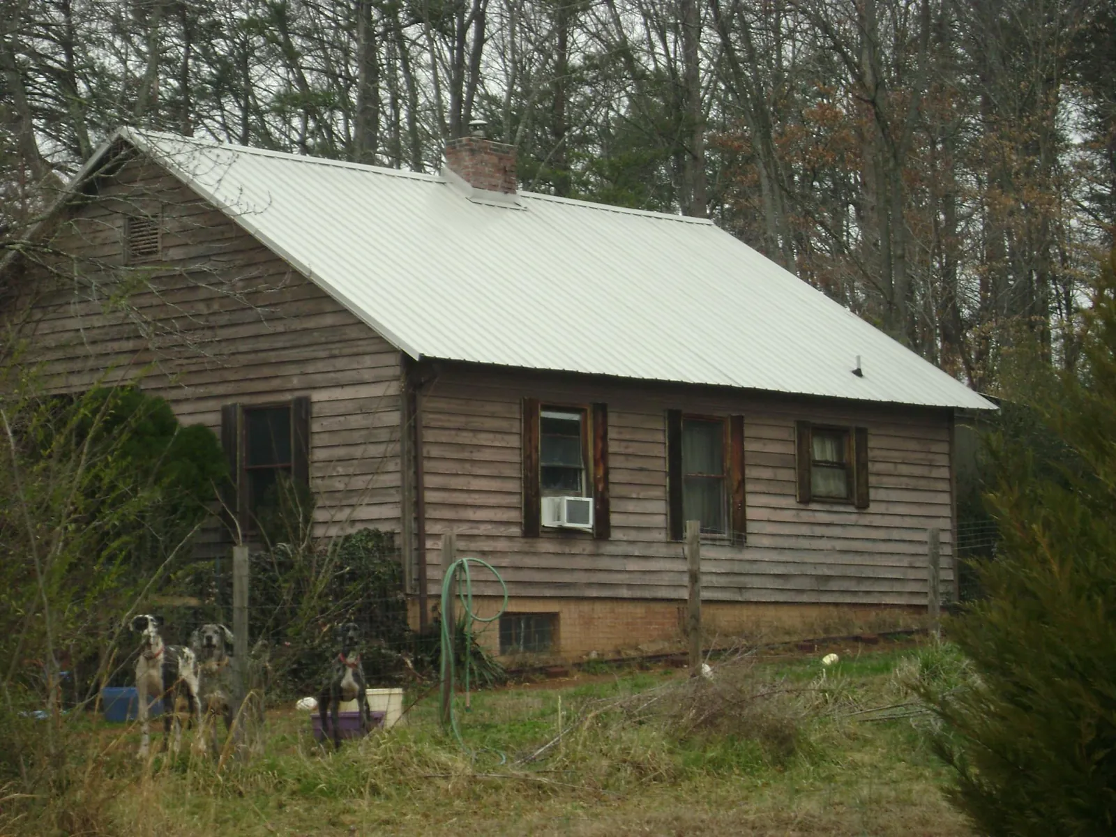 White metal roof on an old wood sided farmhouse, from a Metal Roof Installation job in Grampian